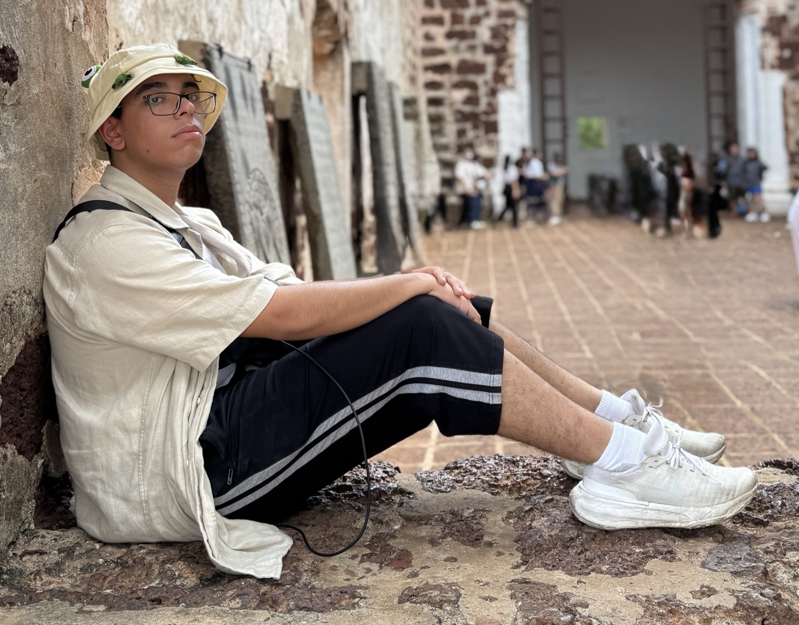 Yousof Selim seated in a stone opening in Melaka